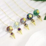 Four gemstone pendulums with gold-tone chains and star-shaped inlays.  Colorful polished gemstone balls.