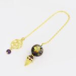 Gold-chained pendulum with star-shaped gemstone.