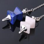 Two gemstone pendulums, one lapis lazuli and one rose quartz, with metal points and chains.  Crystal divination tools.
