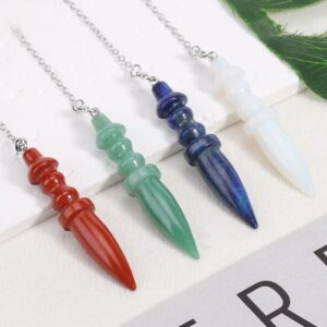 Four gemstone pendulums, red, green, blue, and white, on silver chains.