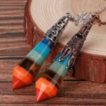 Multicolored layered crystal pendulum,  decorative metal accents.