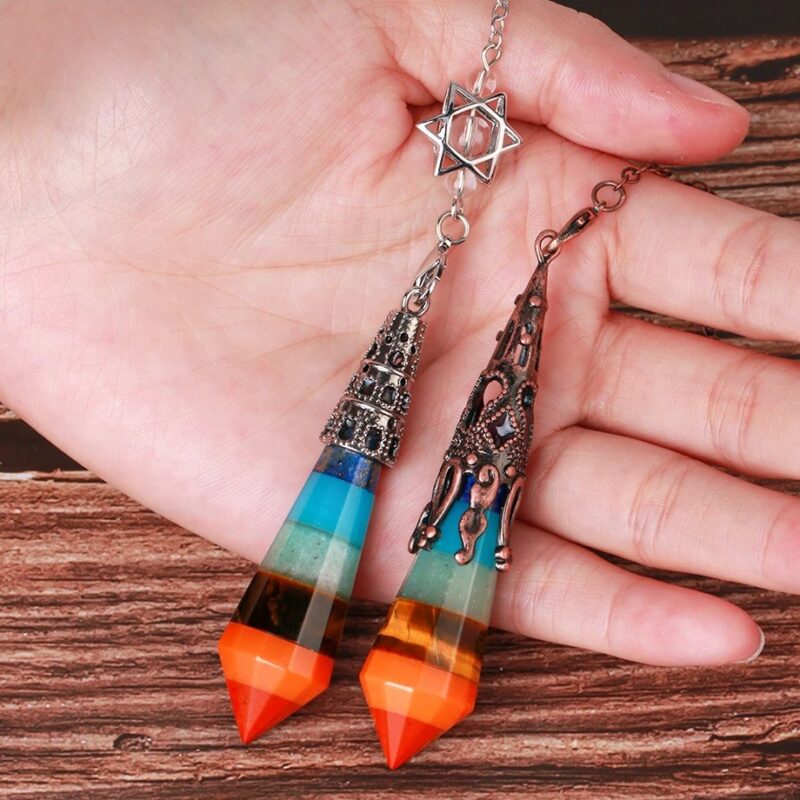 Multicolored gemstone pendulums with metal accents.  Two  pendants,  layered with  different colored stones, one teal/blue and one orange/brown.