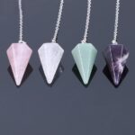 Four gemstone pendulums: rose quartz, clear quartz, green aventurine, amethyst.