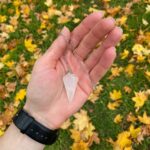 Rose quartz pendulum, held in hand, with chain.