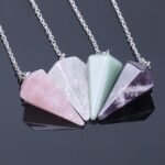 Four crystal pendulums, rose quartz, clear quartz, green aventurine, and amethyst,  on chains.