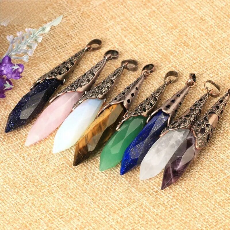 Colorful gemstone pendants, various types of crystals,  in metal settings.