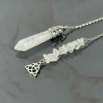 Clear quartz pendulum with metal accents.  Crystal wand and tumbled stones.  Spiritual/healing jewelry.