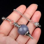 Gray gemstone pendulum with silver chain and metal details.
