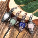 Four gemstone pendulums,  decorative metal frames,  various colors (white, green, blue, pink).