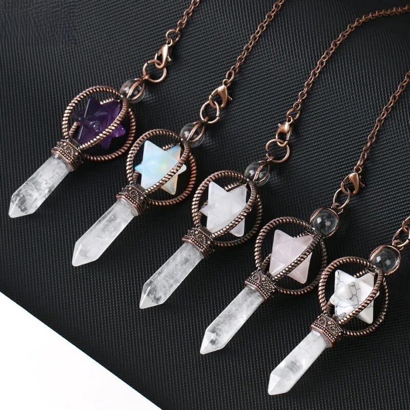 Four crystal pendulums, various colors, with quartz points and decorative metal settings.