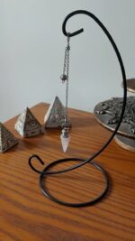 Pink quartz pendulum on metal stand.