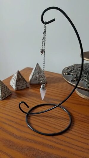 Pink quartz pendulum on metal stand.