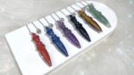 Variety of gemstone pendulums, different colors.