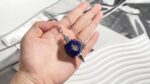 Blue lapis lazuli crystal pendulum with metal chain.