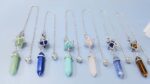 Set of crystal pendulums, various colors,  with metal chain, star and crystal point pendants.
