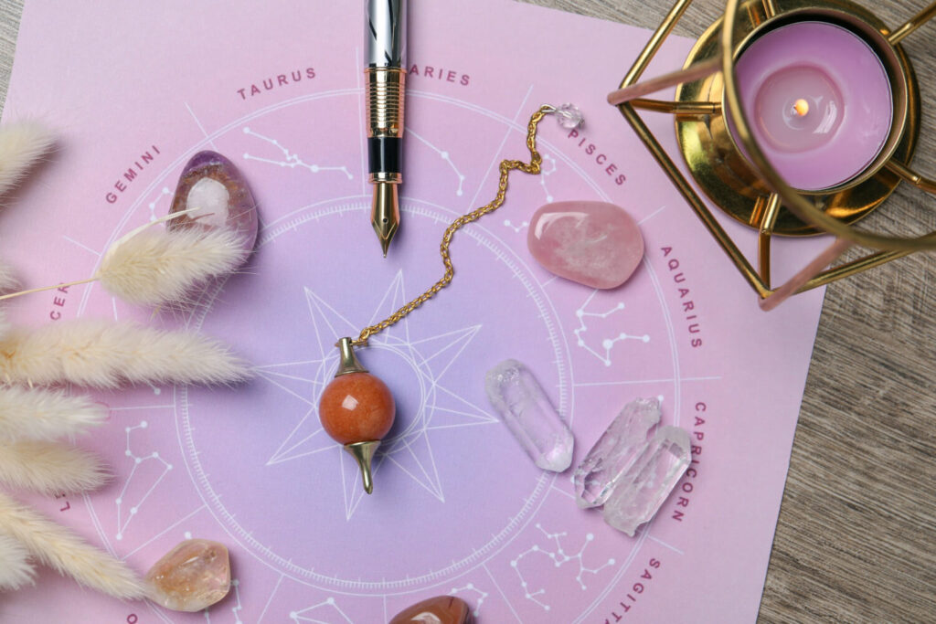 Astrology, crystals, pendulum, candle holder.  Zodiac chart,  various stones, divination tools.
