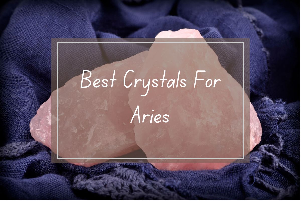 Pink crystals, best for Aries, displayed on a dark-blue fabric.