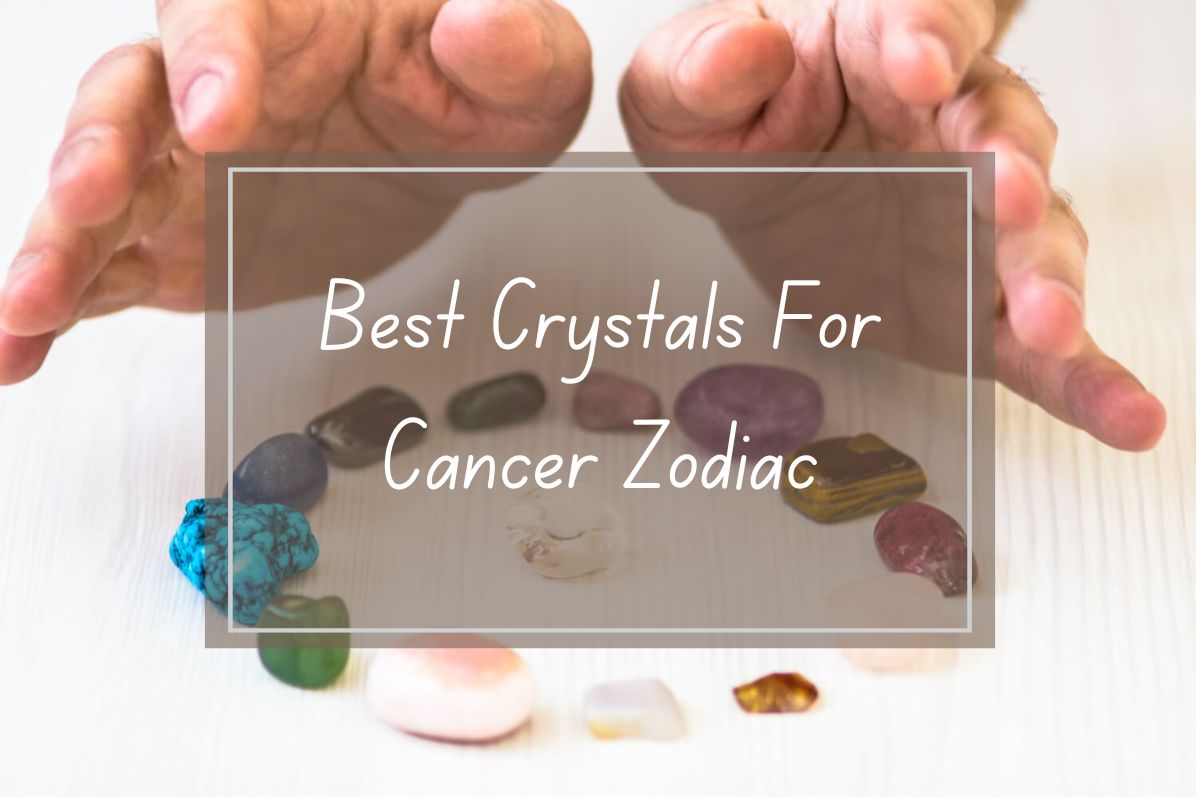 Hands holding healing crystals for Cancer zodiac sign.  Various colored stones arranged on a white surface.