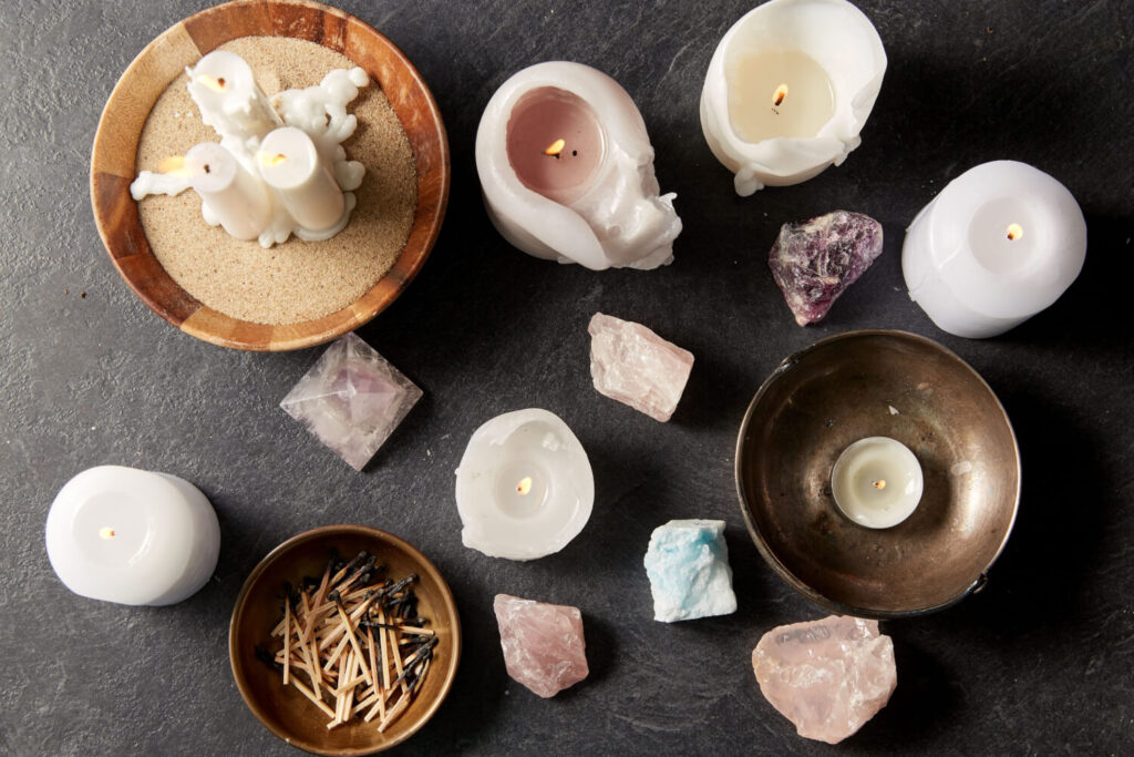 Candles, crystals, and matches on dark surface.  Spiritual, wellness, or meditation imagery.