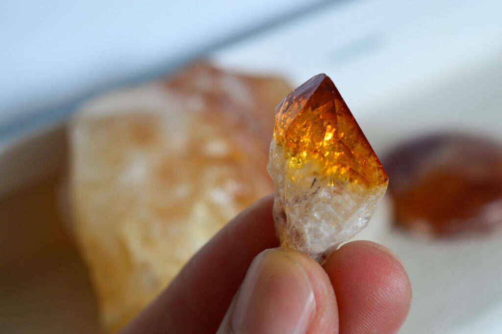 Orange crystal, held in hand.