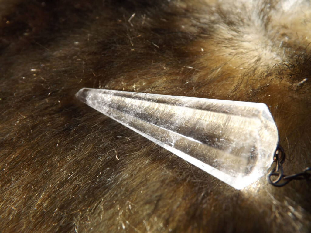 Clear quartz crystal point on faux fur.