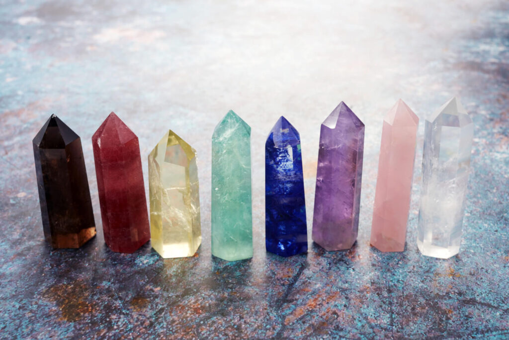 Colorful crystal points, various colors,  on a textured surface.