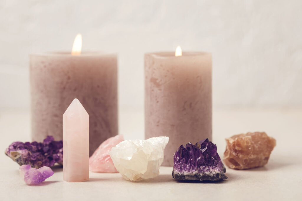 Pink, amethyst, and quartz crystals, with candles.  Spiritual, healing crystals.