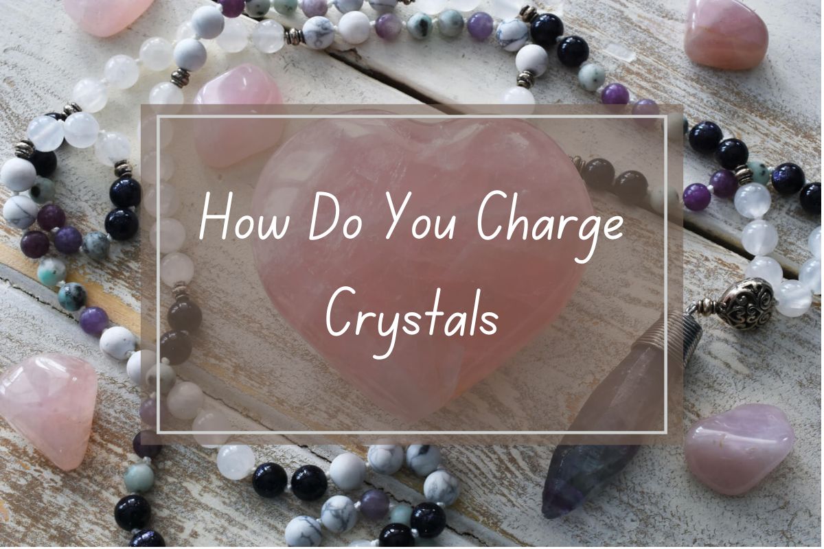 Pink heart-shaped rose quartz crystal, with other crystals and beaded necklaces. Text overlay reads "How Do You Charge Crystals".