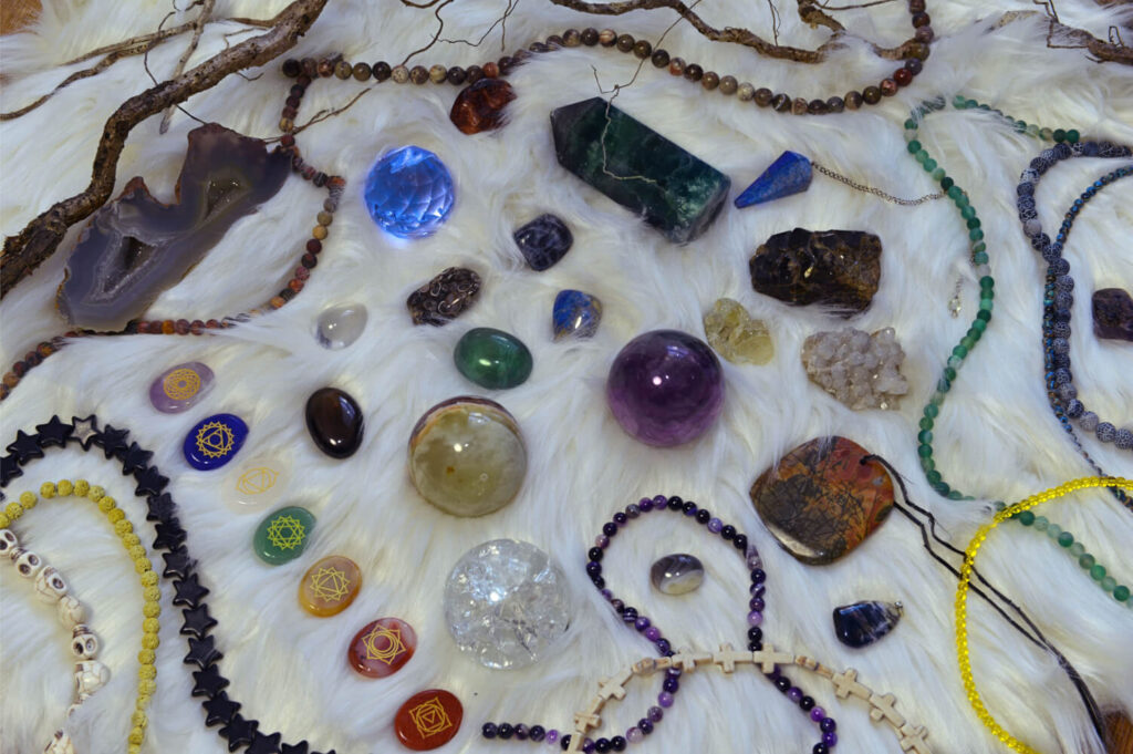 Assortment of crystals, stones, and beads on white fur.  Various colors and shapes.