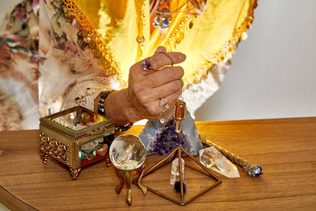 Psychic using pendulum and crystals for divination.  水晶球 占卜.