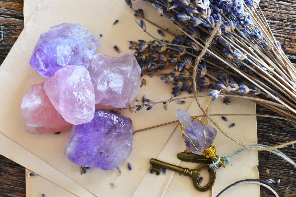 Amethyst and rose quartz crystals, dried lavender, and antique key on vintage paper.  Healing crystals.