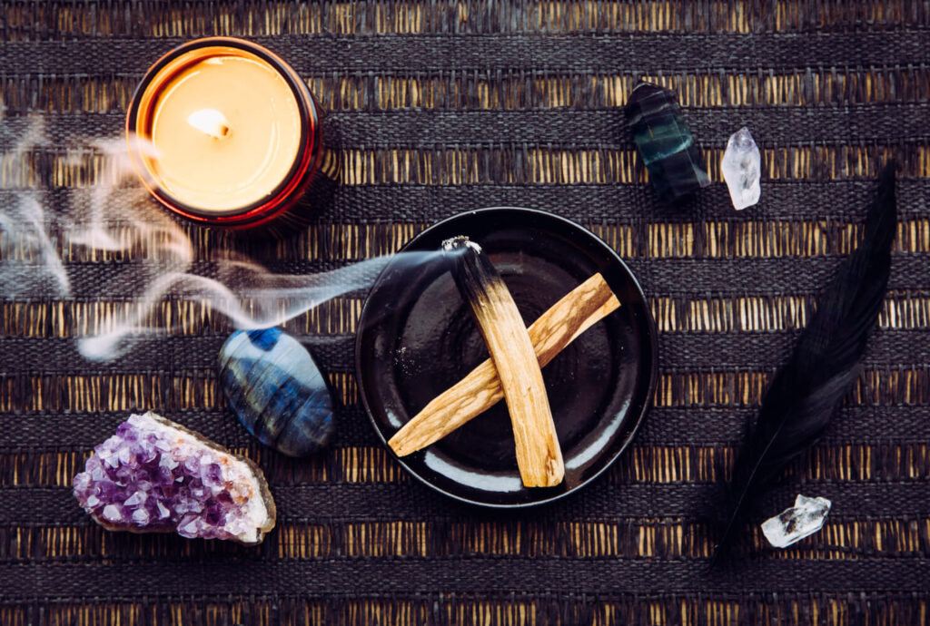 Smudging set with candle, crystals, and feather.