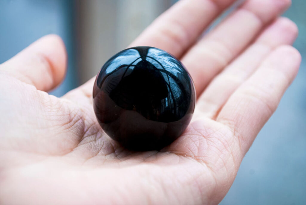 Black sphere held in hand.