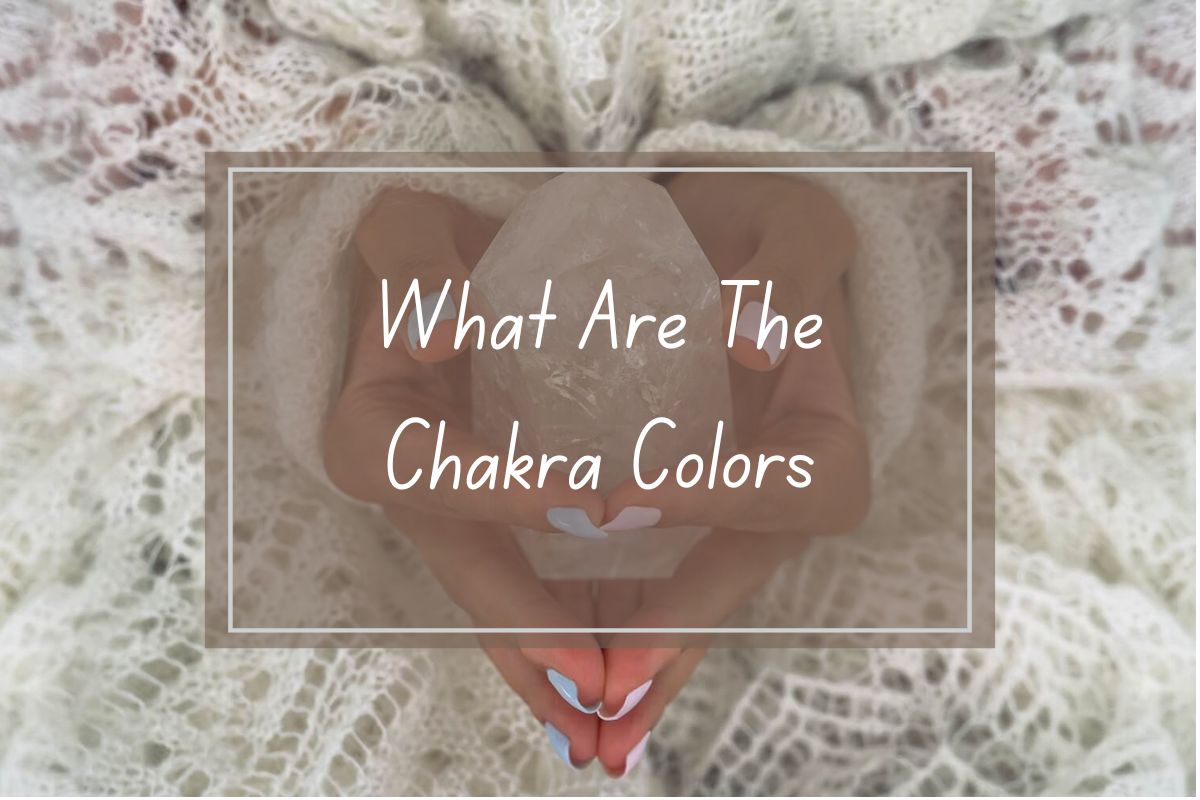 Hands holding a clear crystal, text overlay: "What Are The Chakra Colors".