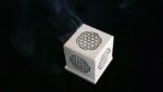 Wooden box with flower of life design, smoke rising.
