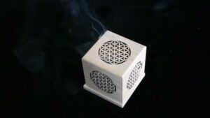 Wooden box with flower of life design, smoke rising.